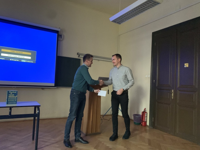 Gecse Krisztián átveszi a bemutatóért és publikációért járó könyvutalványt