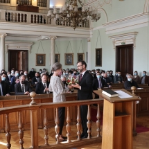 A rektor Adorjáni Mária számára egy csokor virágot nyújt át